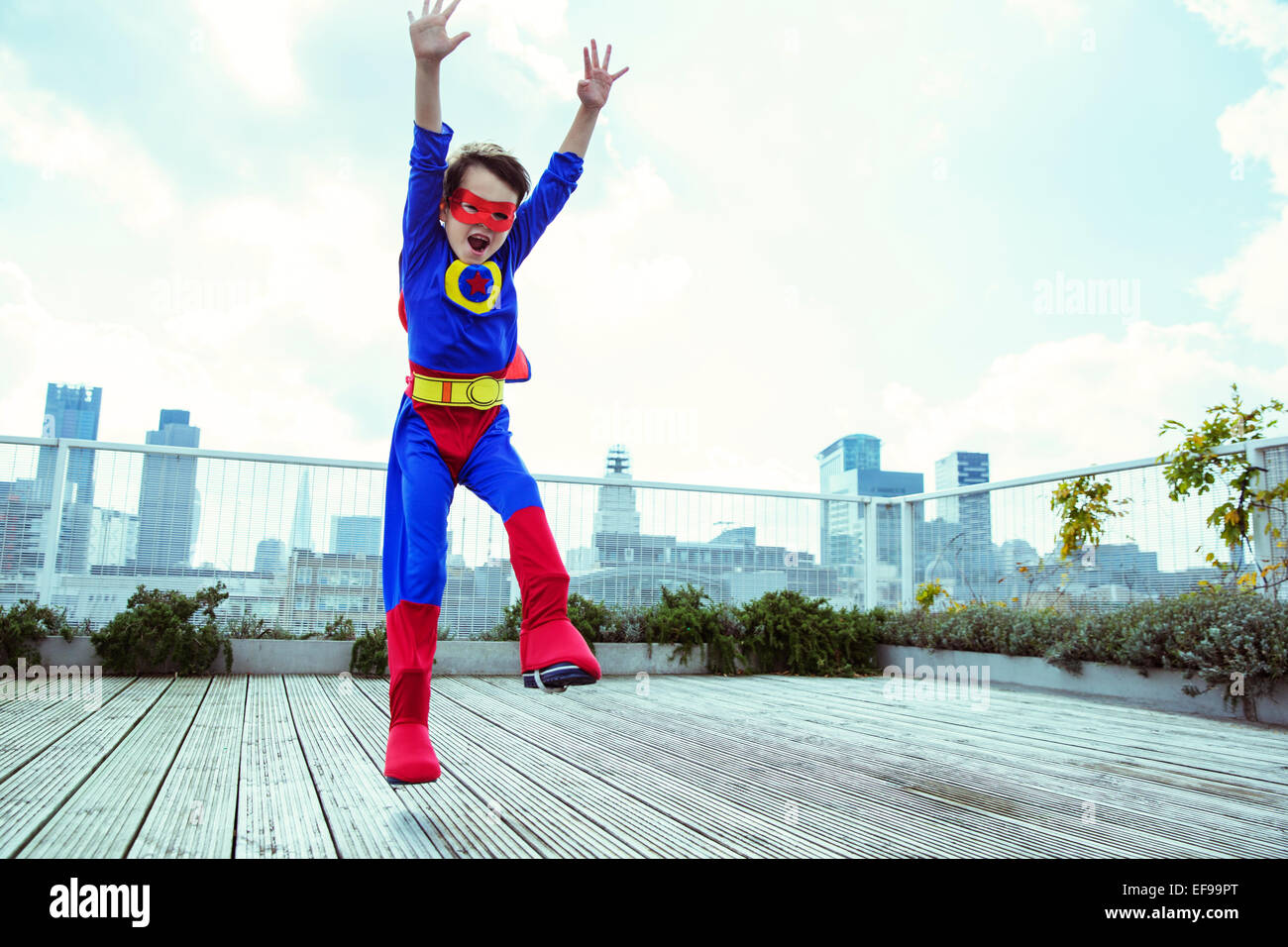 Superhelden-junge springt auf Stadt auf dem Dach Stockfoto