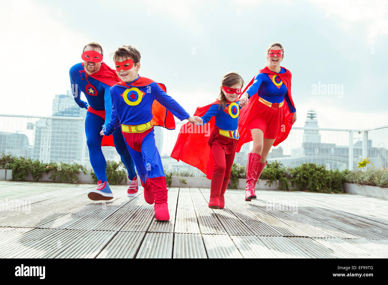Superhelden-Familie spielen auf Stadt auf dem Dach Stockfoto