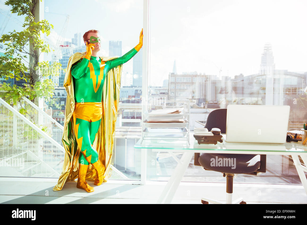 Superheld reden über Handy im Büro Stockfoto