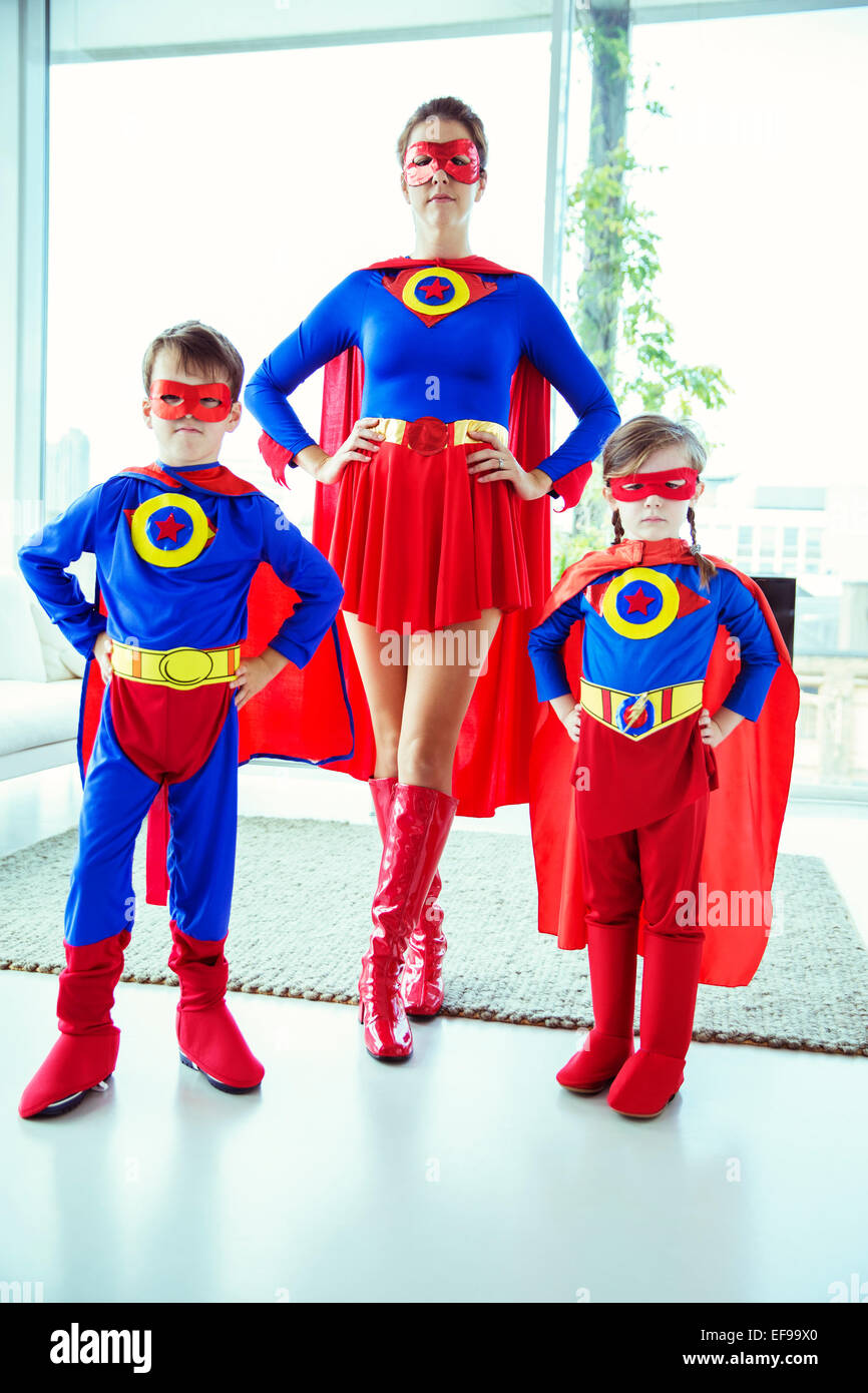 Superhelden-Mutter und Kinder im Wohnzimmer stehen Stockfoto