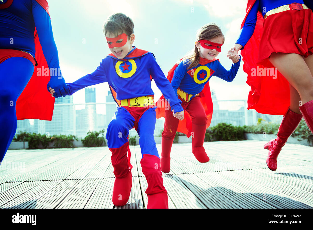 Familie von Superhelden auf Stadt auf dem Dach Stockfoto