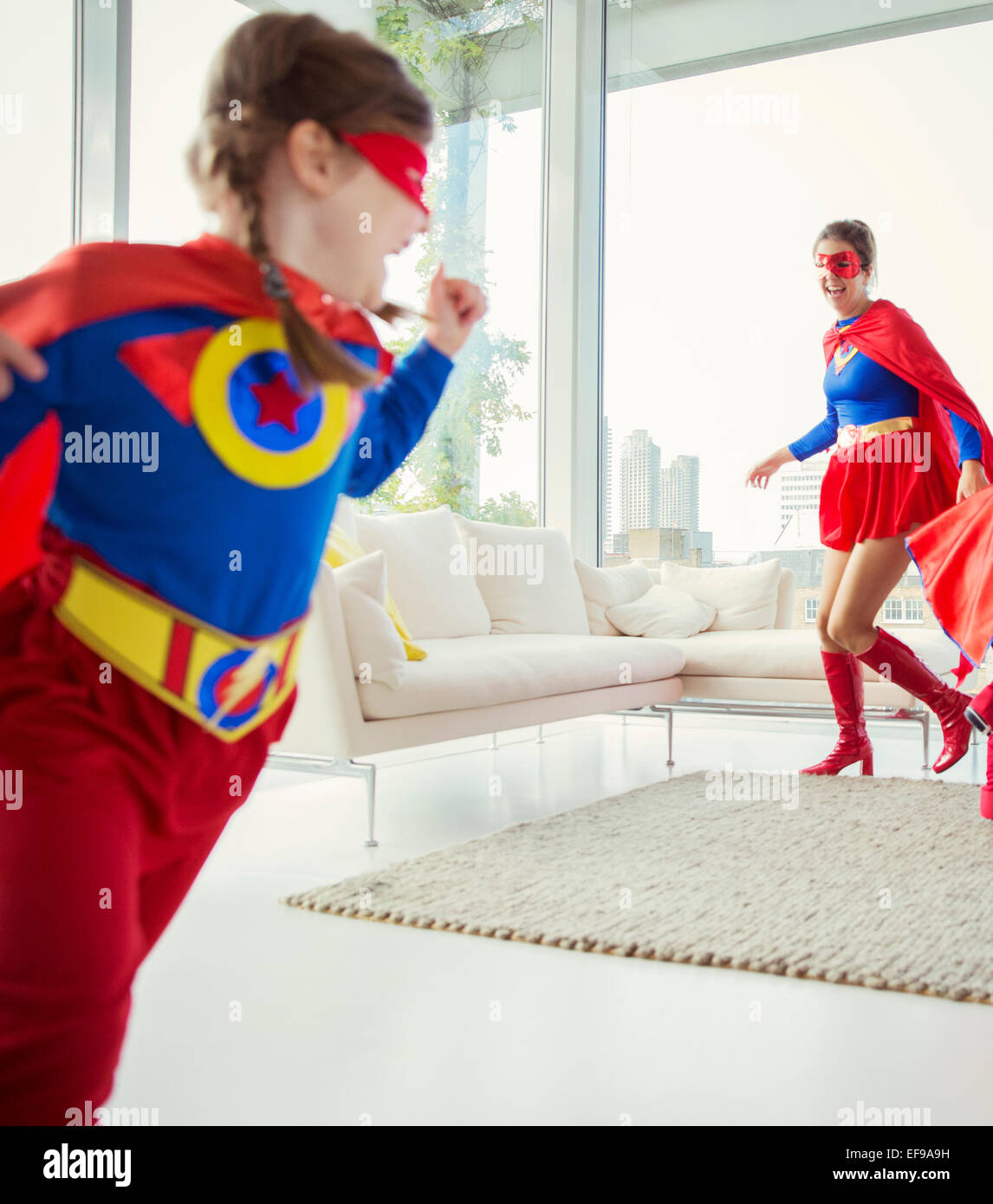 Superhelden-Familie jagten einander im Wohnzimmer Stockfoto