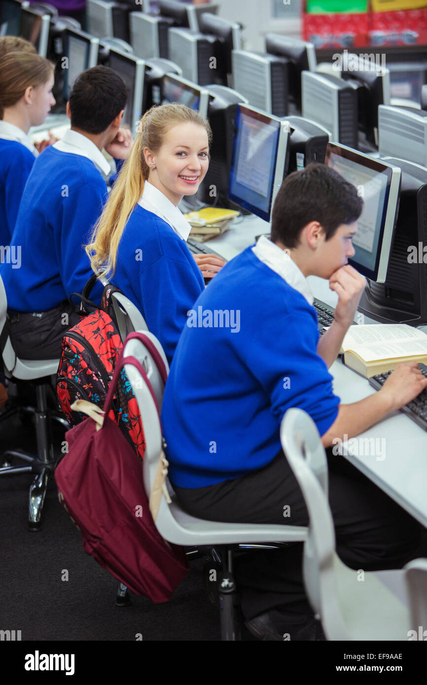 Studenten, lächelnd, sitzen und lernen im Computerraum Stockfoto