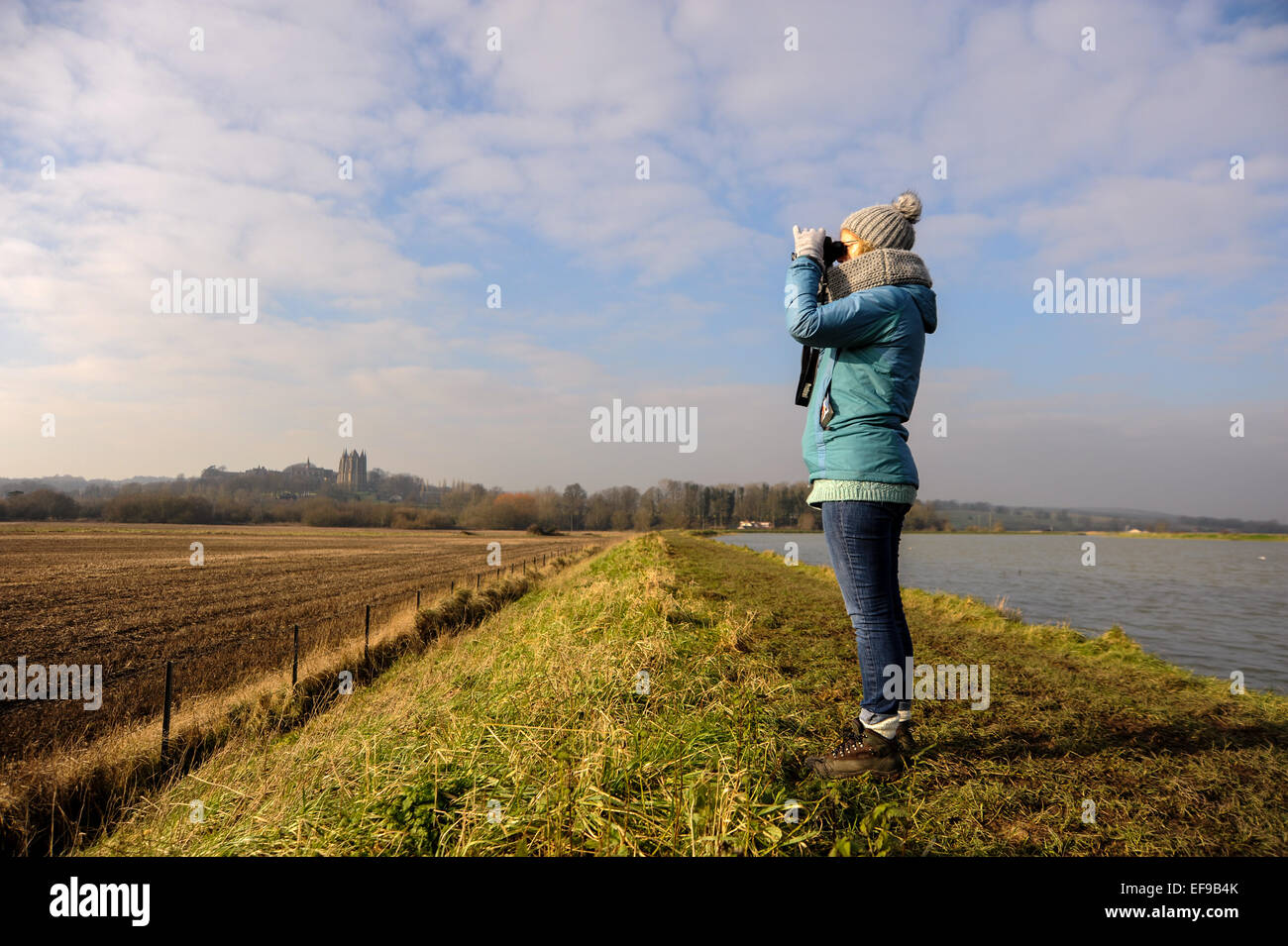 Frau Vogelbeobachtung mit dem Fernglas am Ufer des Fluss Adur in Shoreham UK Stockfoto