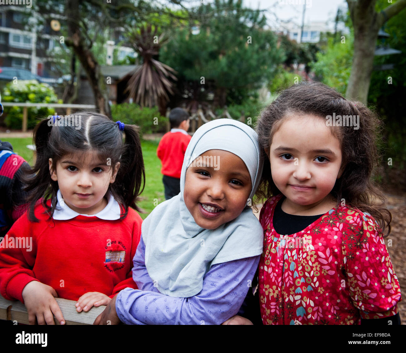 Glücklich lächelnd muslimischen Schülerinnen auf dem Spielplatz der Grundschule in London W2 Stockfoto