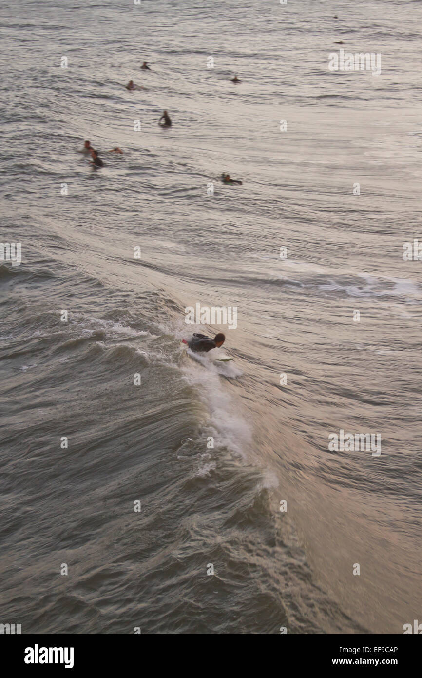 Ein gesehen von oben, eine männliche Surfer reitet ein Ozean Welle von Hurrikan Sandy als andere Surfer beobachten Stockfoto