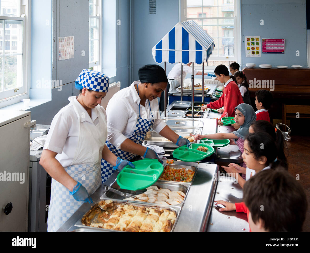 Schulessen in der UK State Primary School Dinner Damen servieren Kinder in der Primary School Stockfoto