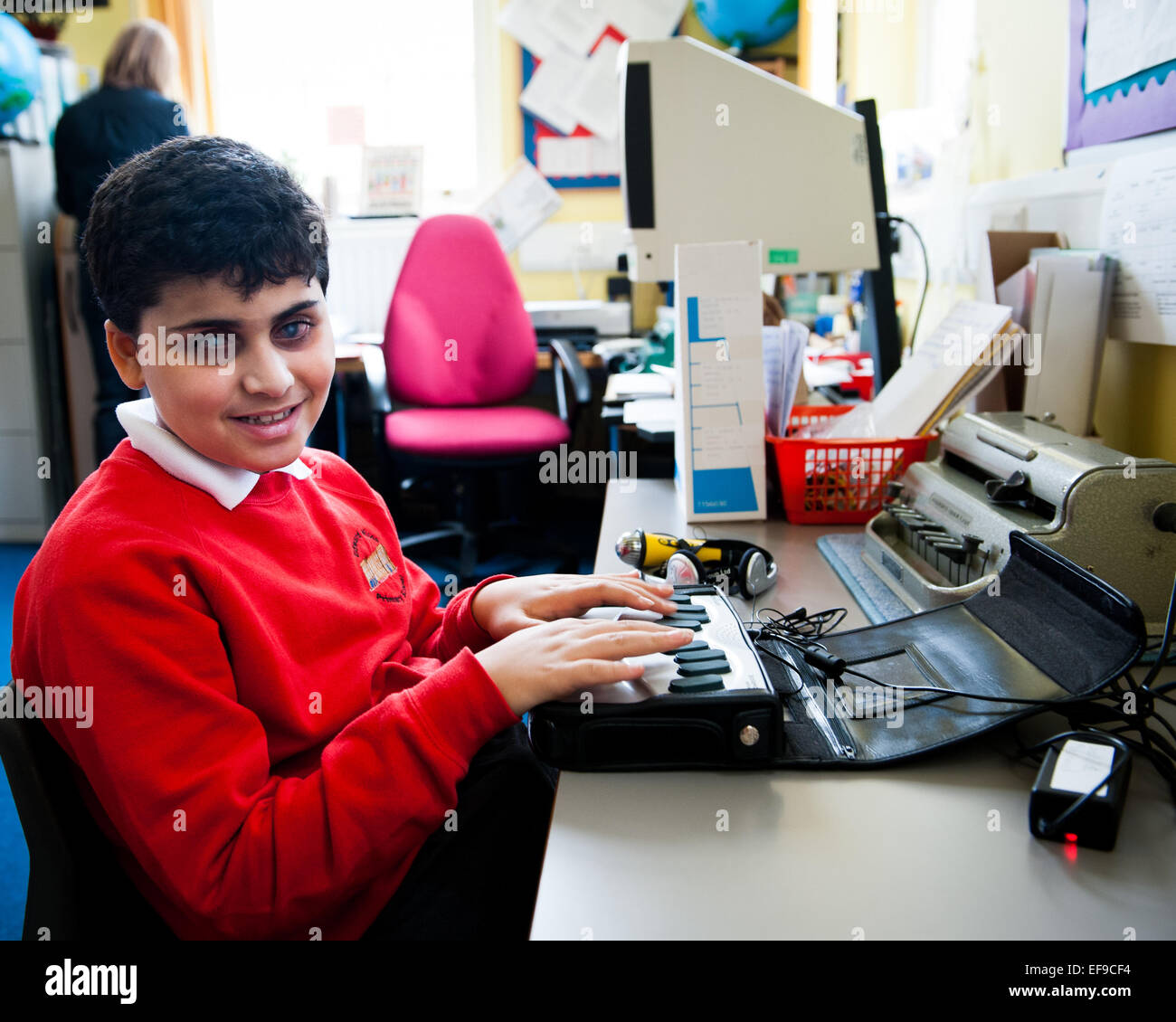 Blinder mit Braille-Maschine in Special Needs Klasse in London Grundschule Stockfoto
