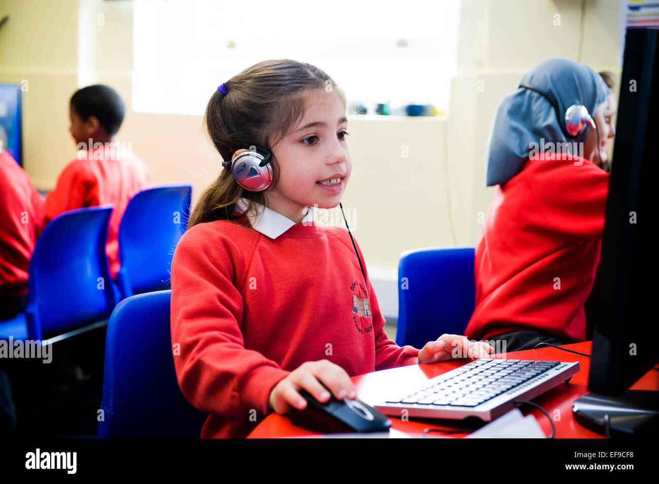 Mädchen in der Grundschule eine Online-Mathe-Klausur zu tun und mit ihren Fingern zählen Stockfoto