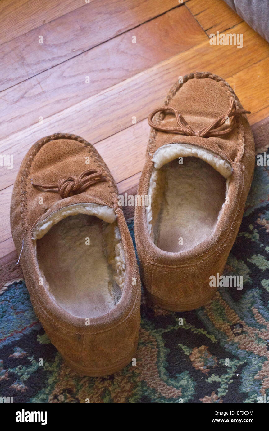 Nahaufnahme eines gemütlichen, gut getragen, Leder Pantoffeln auf einem bunten Teppich Stockfoto
