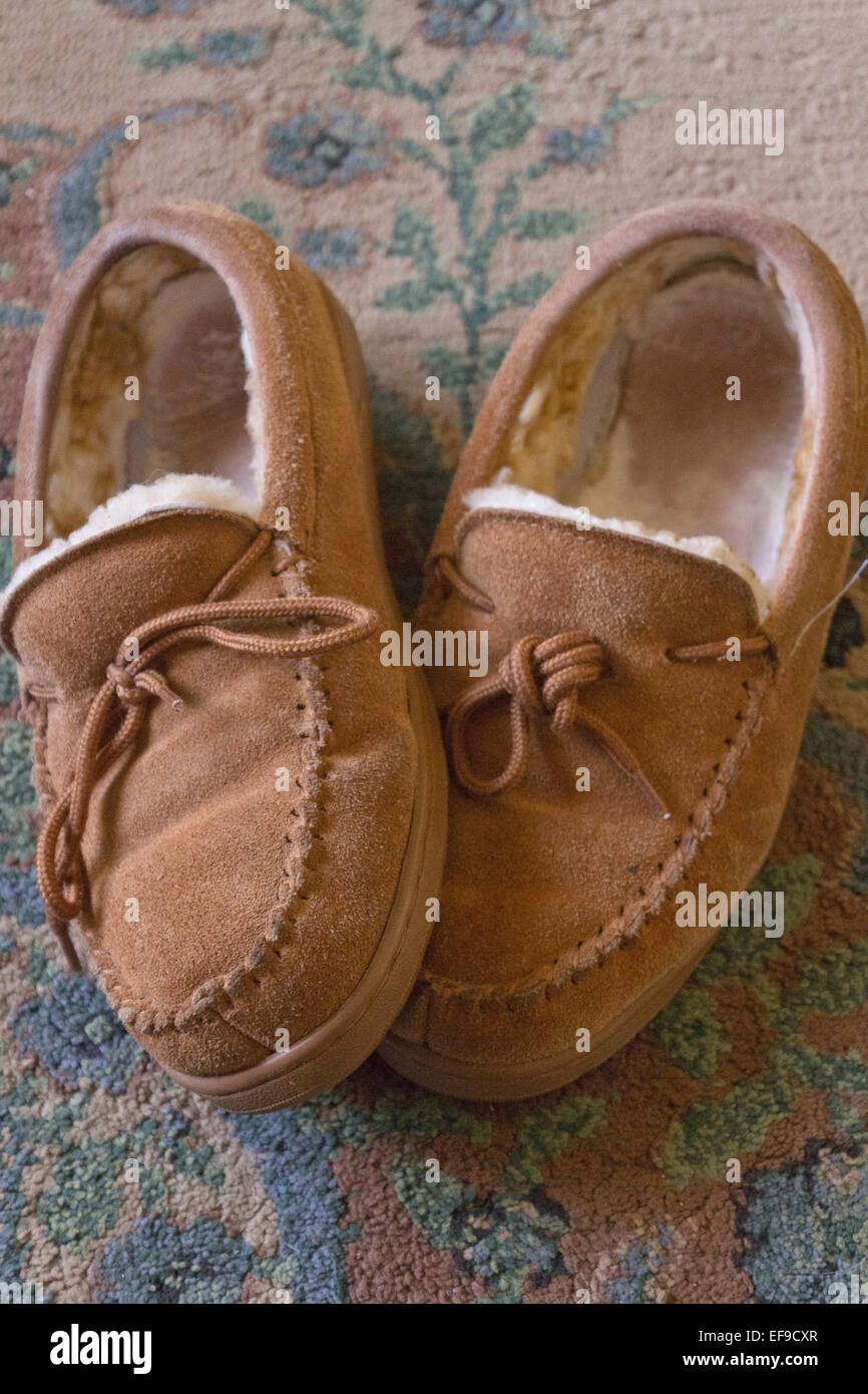 Nahaufnahme eines gemütlichen, gut getragen, Leder Pantoffeln auf einem bunten Teppich Stockfoto