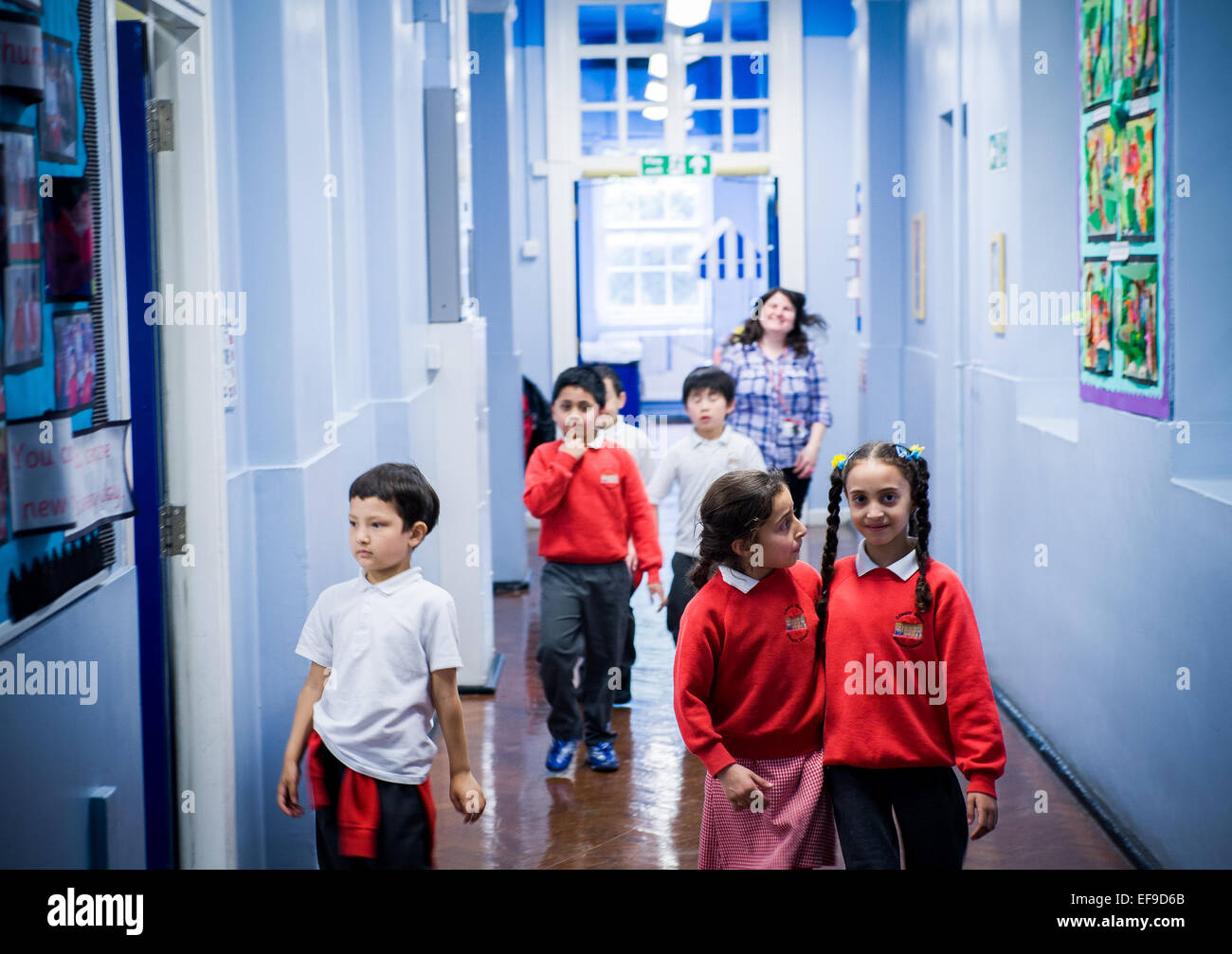 Kinder zu Fuß durch den Korridor zwischen den Unterrichtsstunden Grundschule, London UK Stockfoto