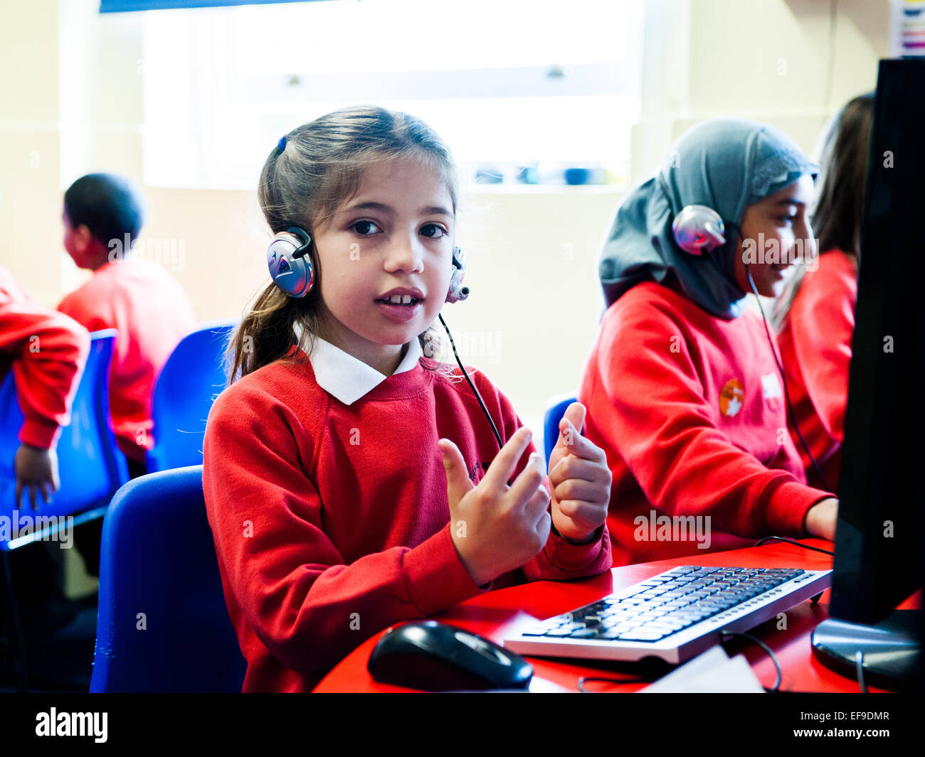 Mädchen in der Grundschule eine Online-Mathe-Klausur zu tun und mit ihren Fingern zählen Stockfoto