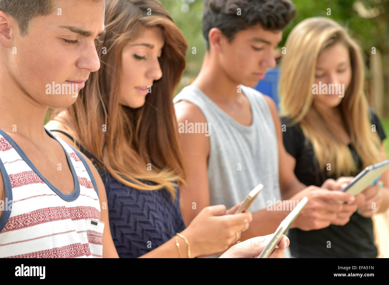 Junge Teenager spielen auf Tablet und Smartphone Stockfoto