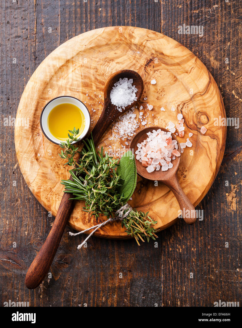 Verschiedene Arten von Lebensmitteln grobes Salz in Holzlöffel auf dunklem Hintergrund Stockfoto