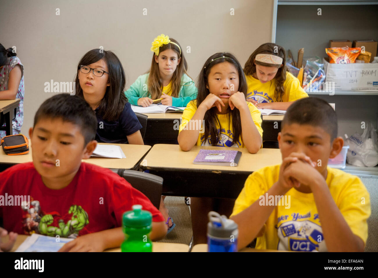 Zeigt eine Vielzahl von Ausdrucksformen, Asien, Hispanic und kaukasischen Mittelschule Studenten anhören ihrer Lehrer an ein Schreibprojekt Klasse in Irvine, CA. Notiz T Shirts. Stockfoto