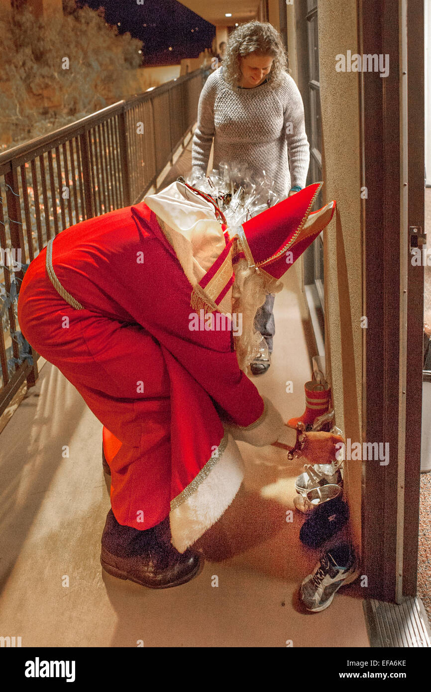 Katholische Kirche St. Timothy, Laguna Niguel, CA, ein Gemeindemitglied als St. Nikolaus ihre Schuhe draußen ein Bastelraum im Advent für Kinder Weihnachtsgeschenke stellenweise gekleidet. Stockfoto