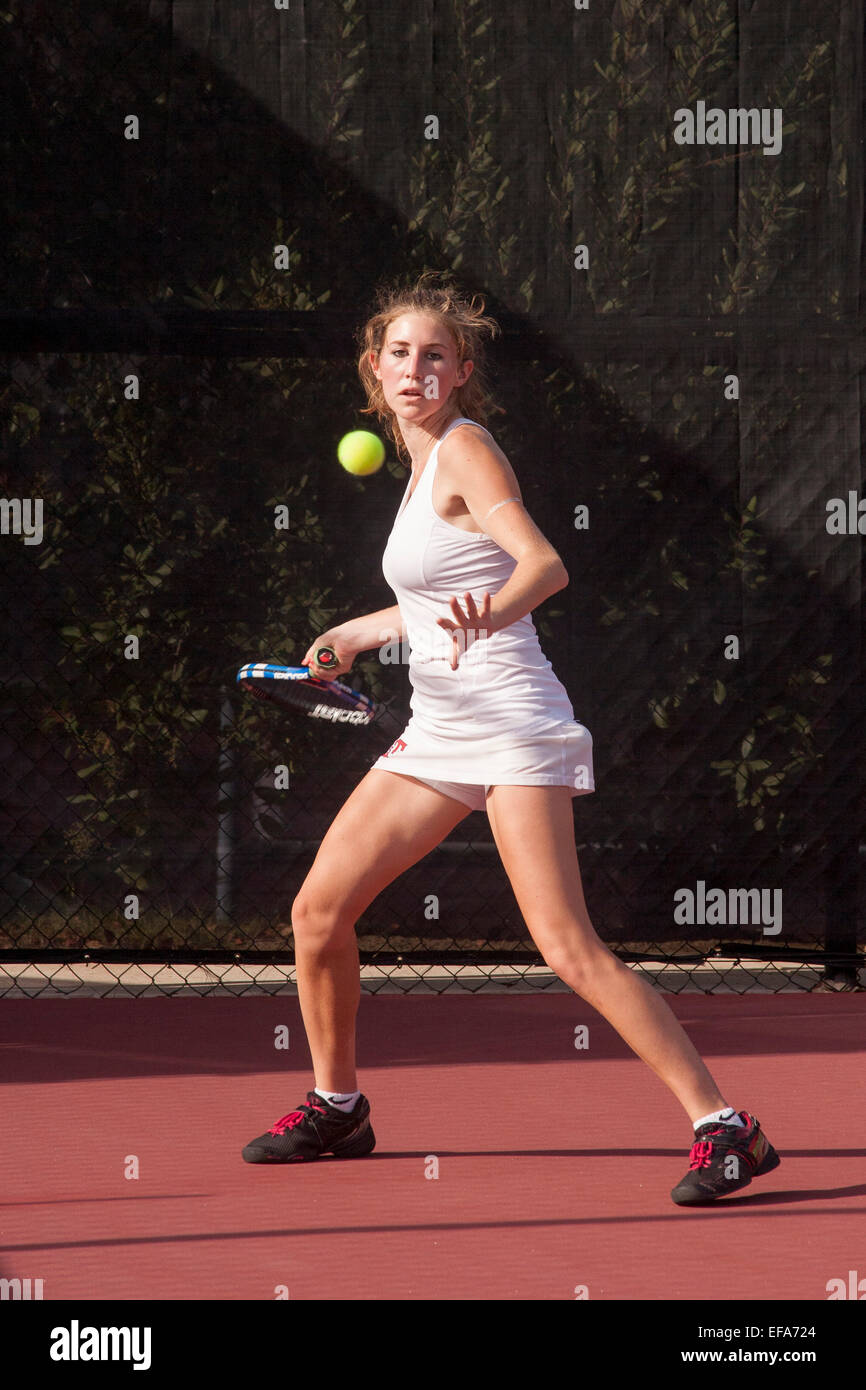 Mit sorgfältige Timing bereitet ein junge Frau Tennisspieler eine dienen in San Juan Capistrano, Kalifornien zurück. Stockfoto