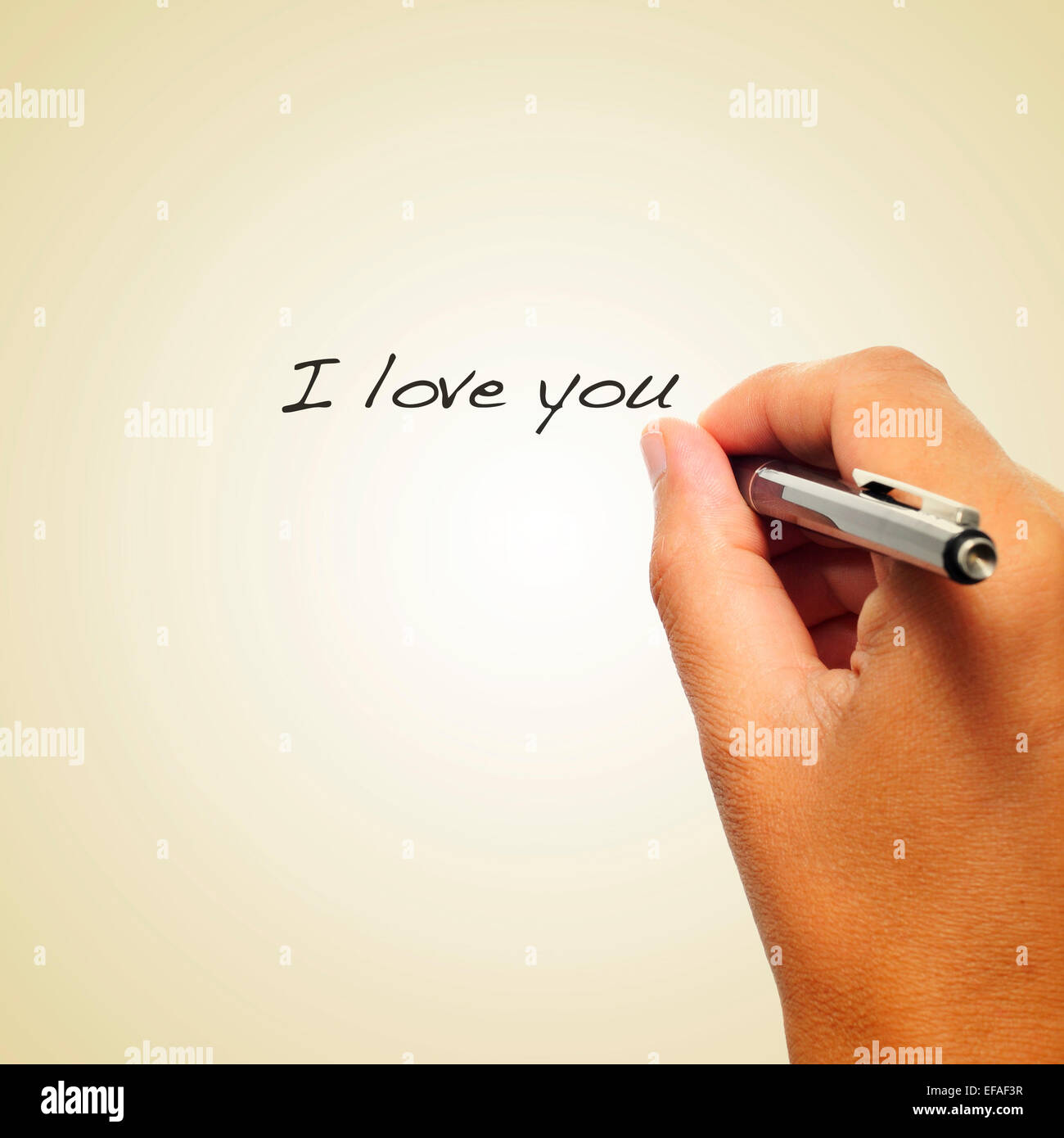 Nahaufnahme der Hand eines Mannes schreiben mit einem Stift dem Satz, ich liebe dich auf einem beigen Hintergrund, mit einem Retro-Effekt Stockfoto
