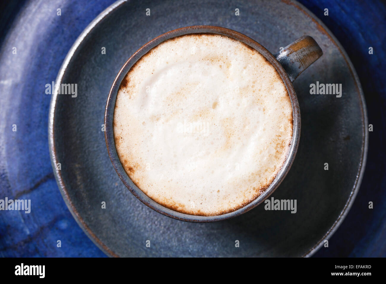 Blaue Keramik Tasse Cappuccino über blaue Keramik Tablett. Ansicht von oben. Stockfoto