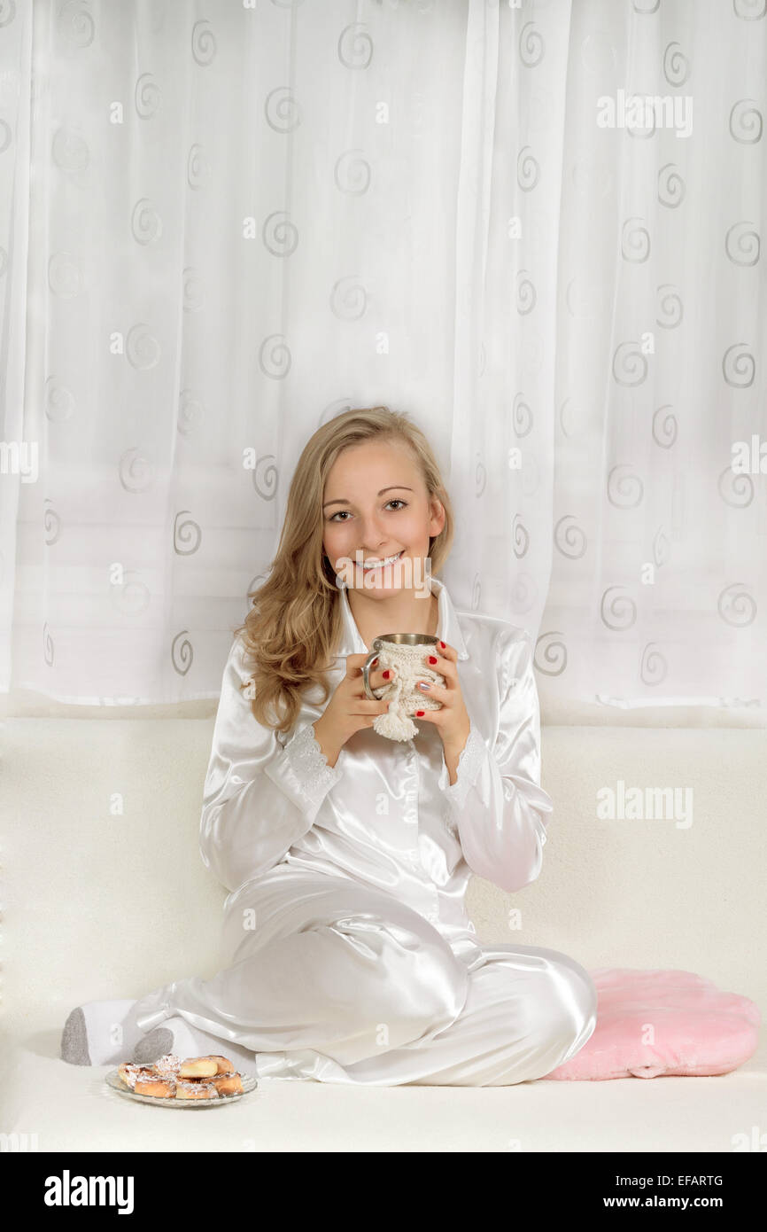 Junge Frau im Schlafanzug mit heiß trinken Stockfoto