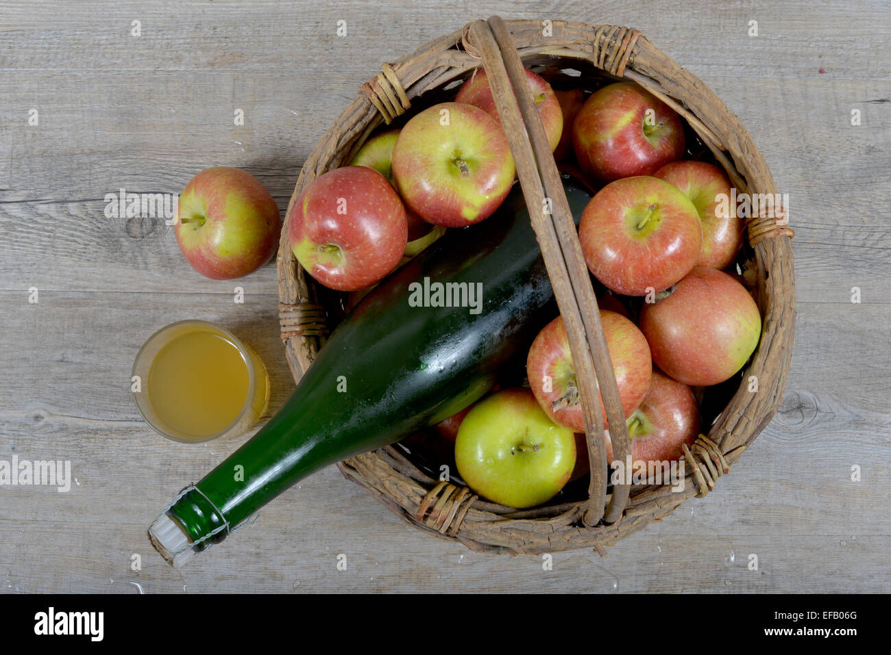Apfelkorb und Flasche Apfelwein Stockfoto