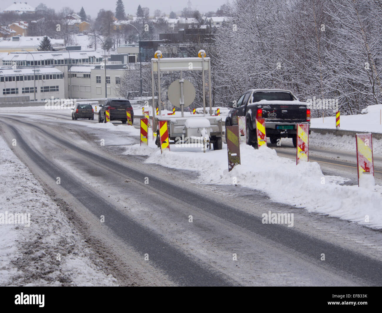 Winter-Baustellen, notwendig aber Schnee bringt zusätzliche Herausforderungen für Autofahrer und Arbeitnehmer gleichermaßen, Oslo Norwegen Stockfoto