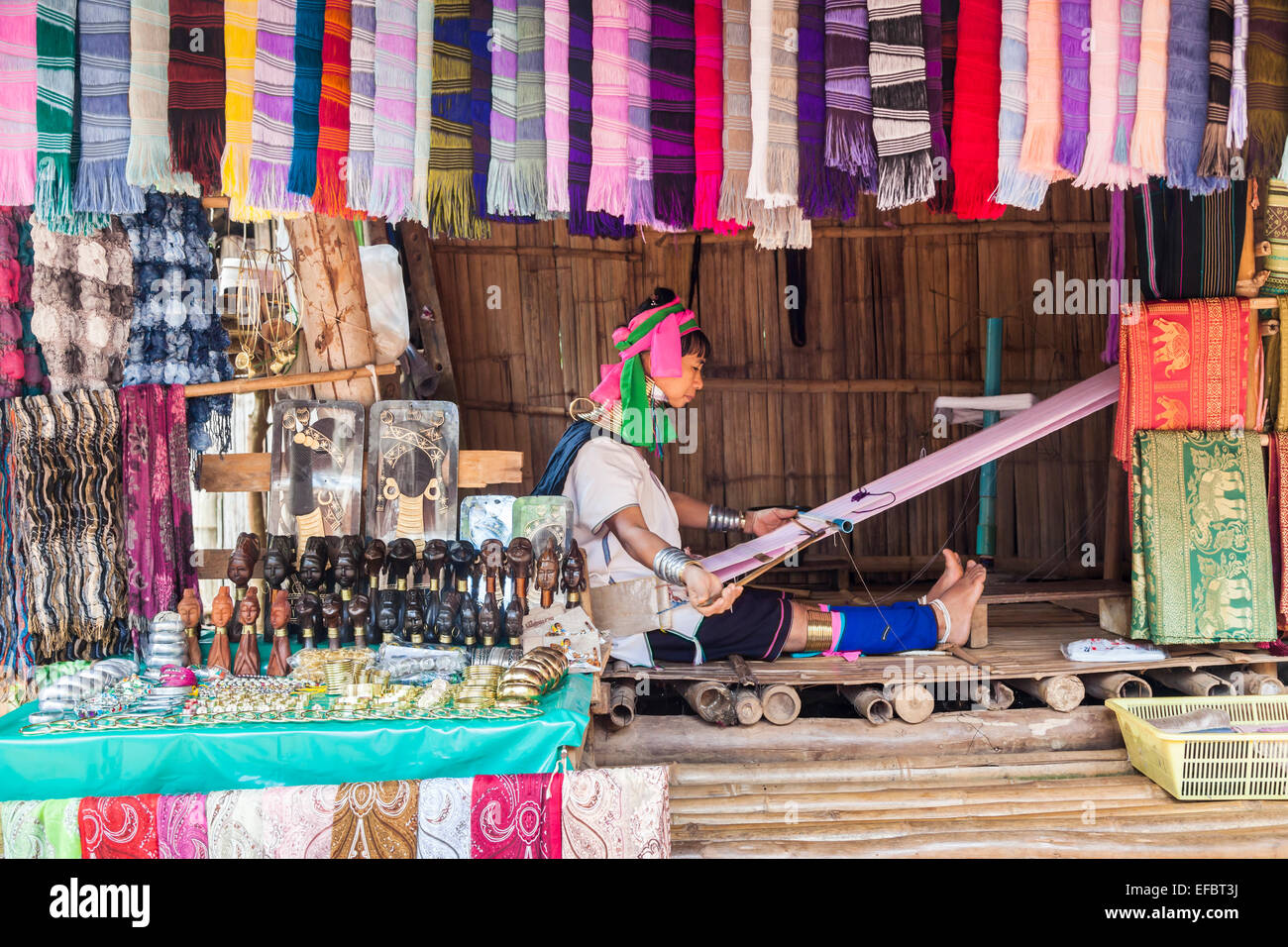 Langer Hals burmesischen Frau in einem bunten Kopfschmuck Karen Padong Village in der Nähe von Chiang Rai, Thailand, auf einem Webstuhl weben Stockfoto