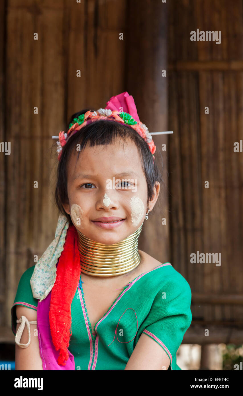 Süße junge burmesische Langhals-Mädchen mit einem bunten Stirnband, grüne Bluse und Sonne Bildschirm in Karen Padong Dorf, Thailand Stockfoto