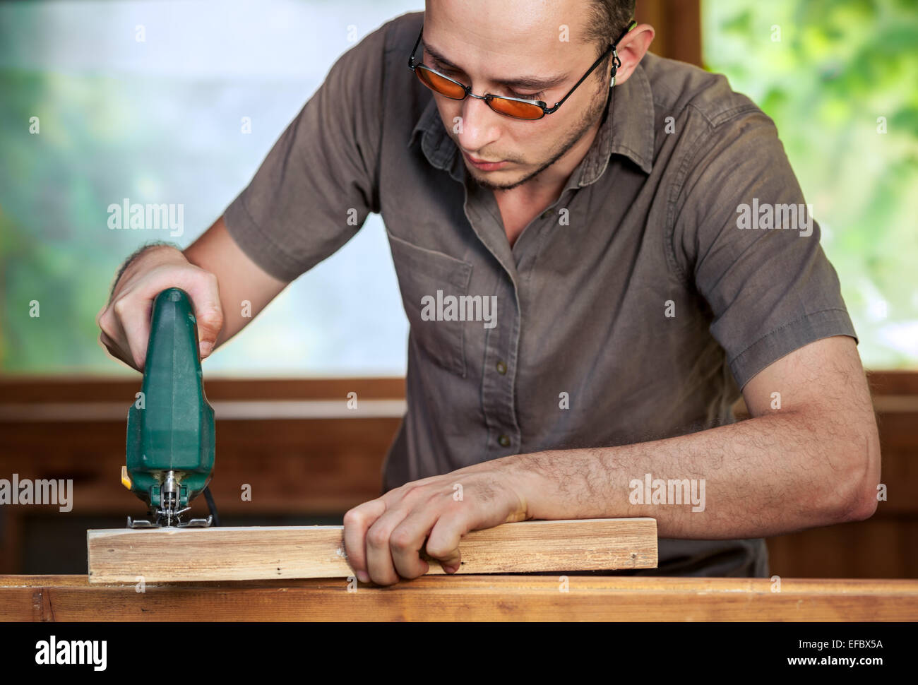 Junger Mann mit Holz zu arbeiten Stockfoto