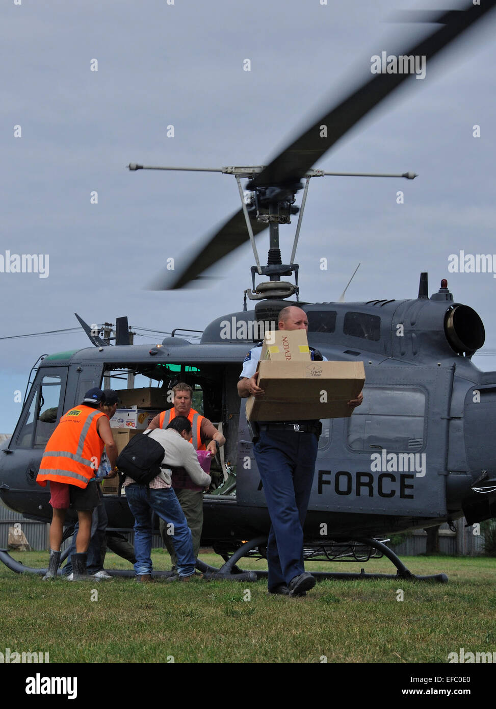 CHRISTCHURCH, NEW ZEALAND, 22. Februar 2011: freiwillige Relief Arbeiter Gerangel um die Versorgung mit Nahrungsmitteln aus einer Luftwaffe Hubschrauber Stockfoto