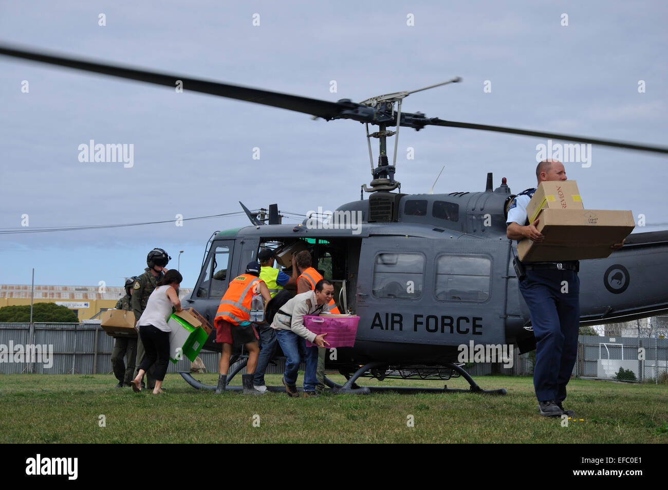 CHRISTCHURCH, NEW ZEALAND, 22. Februar 2011: freiwillige Relief Arbeiter Gerangel um die Versorgung mit Nahrungsmitteln aus einer Air Force Ihelicopter Stockfoto