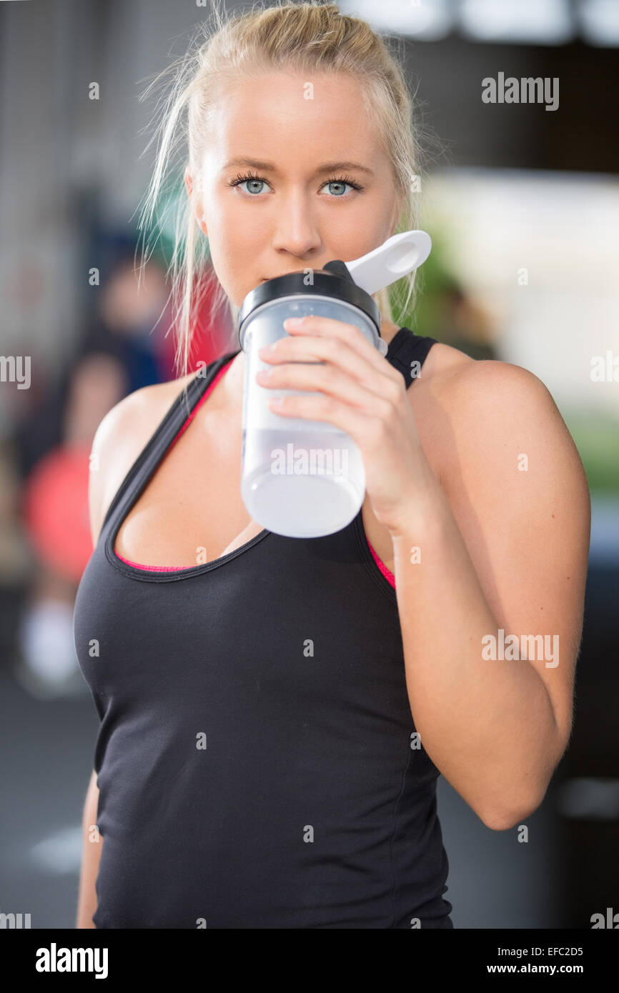 Blondes Mädchen trinkt Wasser Gym Fitnesscenter Stockfoto