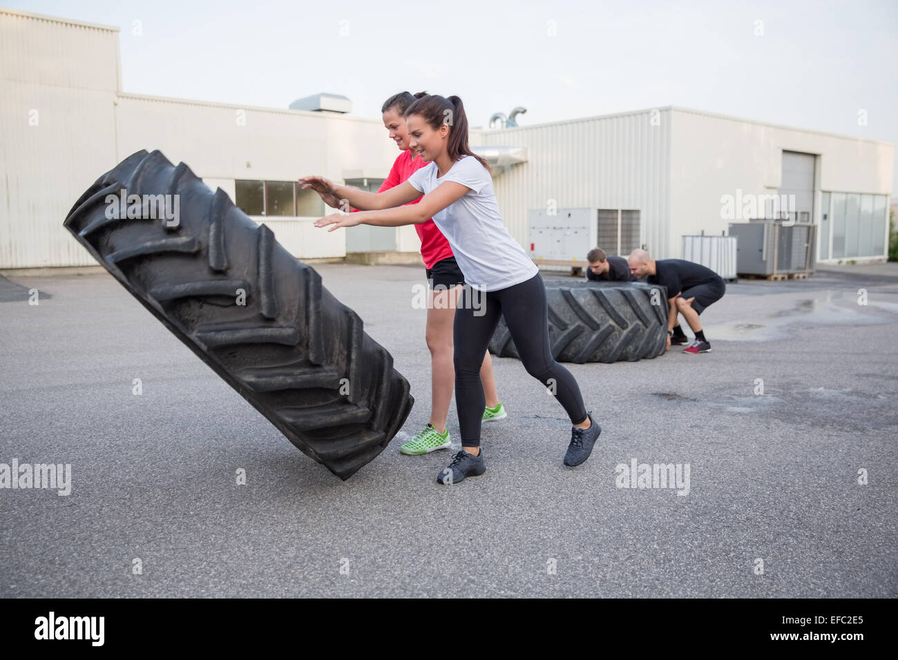 Gruppe von Menschen spiegeln schweren Reifen als workout Stockfoto