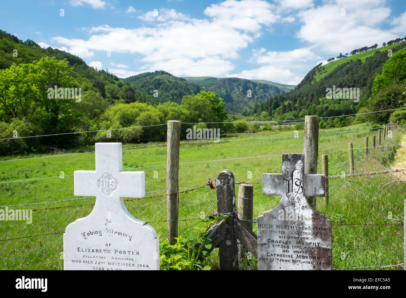 Historische Grabsteine und eine Aussicht auf das Tal an Glendalough, Irland Stockfoto