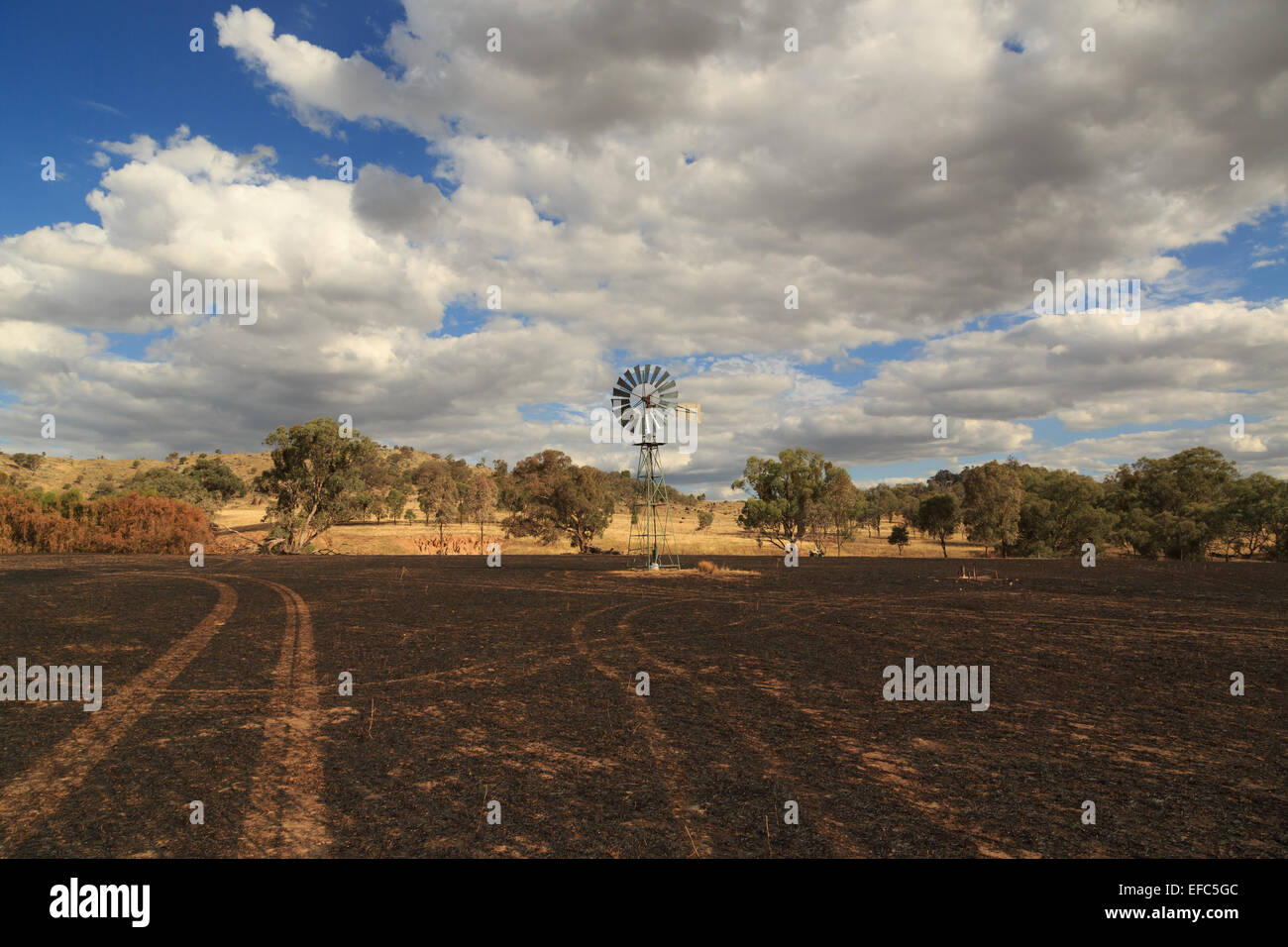 Ein Foto von einer Windmühle im Anschluss an ein Buschfeuer auf einer trockenen australischen Farm im zentralen westlichen NSW. Stockfoto