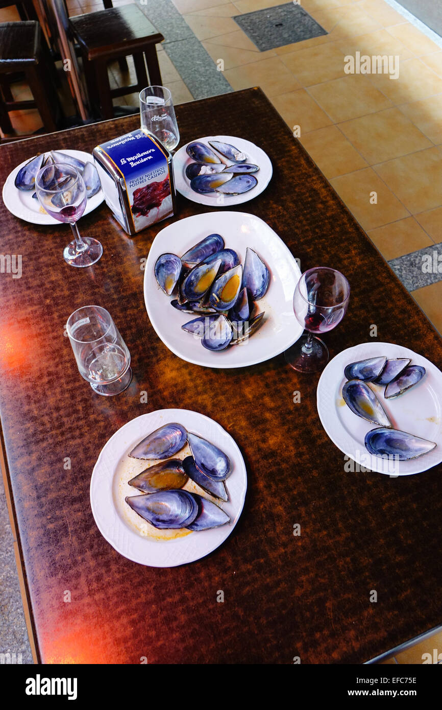 Leere Muschelschalen auf fünf weiße Platten mit leeren Weingläser auf einem Tisch, Benidorm, Costa Blanca, Spanien nach einer Mahlzeit Stockfoto