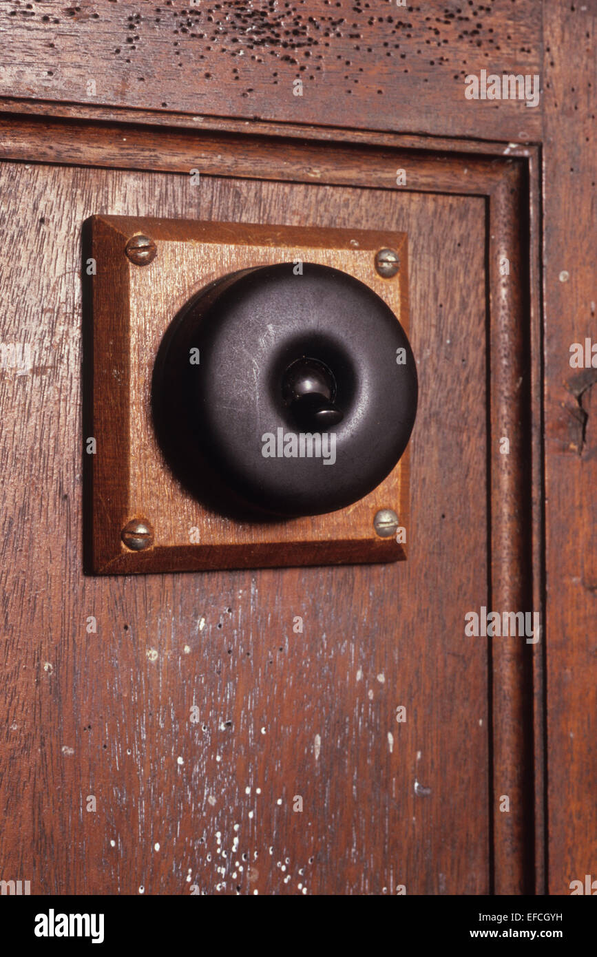 Vintage Bakelit schwarz elektrisches Lichtschalter auf Holz montiert und verschraubt, Holzplatte mit Gebrauchsspuren Stockfoto