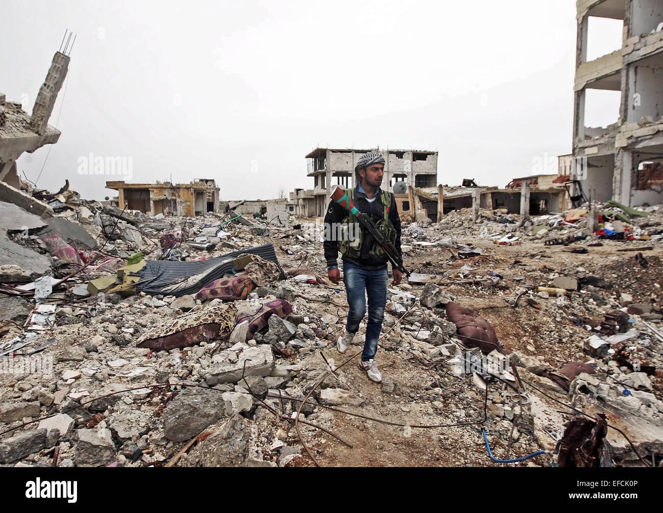 (150131)--ISTANBUL, 31. Januar 2015 (Xinhua)--A kurdische militanten Patrouillen in den Ruinen nach einer fünfmonatigen zwischen den kurdischen Kämpfern und der islamischen State(IS) militante Gruppe in Ain al-Arab, Syrien, am 31. Januar 2015 Zusammenstöße. Die kurdischen Kämpfer geworden volle Kontrolle über die überwiegend kurdischen Stadt Ain al-Arab in Nordsyrien. Eine massive Zerstörung beobachtet in der Stadt, wo fast alle Gebäude während der Luftangriffe zusammengebrochen waren. Die leeren Straßen werden jetzt von kurdischen Kämpfern patrouilliert und kaum Zivilisten außerhalb beobachtet wurden. Ende 2014, der IS entfesselt eine Stockfoto