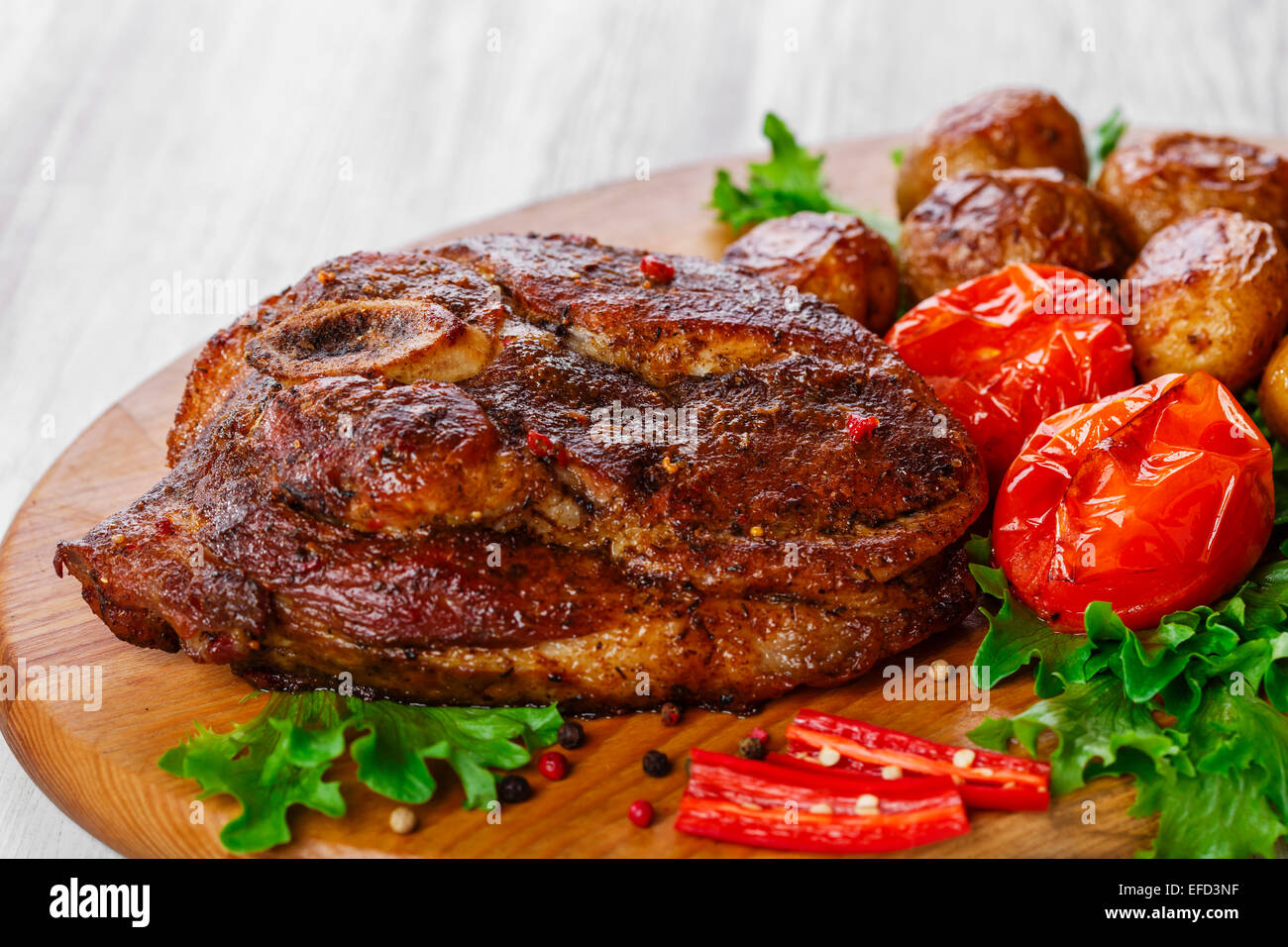 Gebratene Schweineschulter mit Knochen mit Kartoffeln Stockfoto