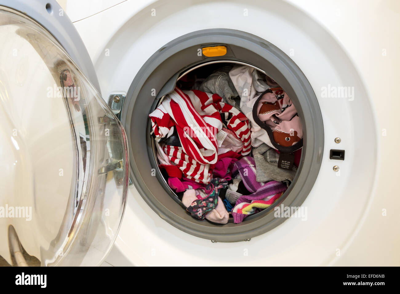 Nahaufnahme einer offenen Waschmaschine voller schmutziger Wäsche zu waschen Stockfoto