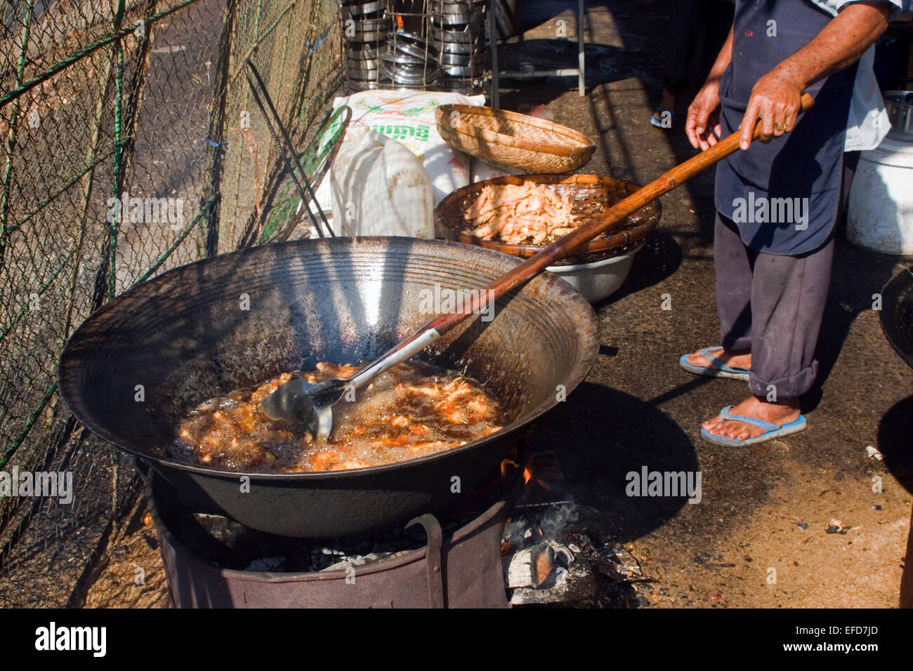 Ein Mann kocht Streetfood auf einer Stadtstraße in Kampong Cham, Kambodscha. Stockfoto