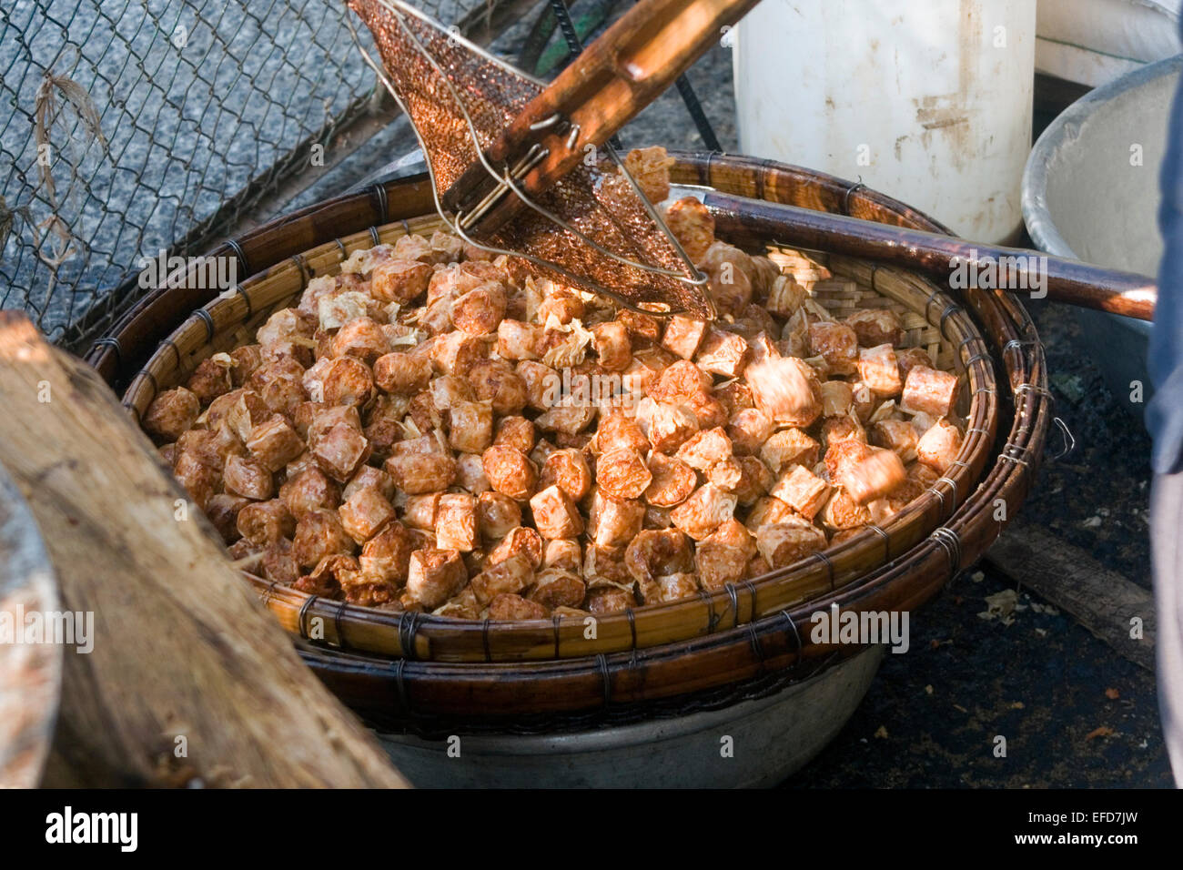 Ein Mann ist street essen Fleisch im heißen Öl auf einer Stadtstraße in Kampong Cham, Kambodscha braten. Stockfoto