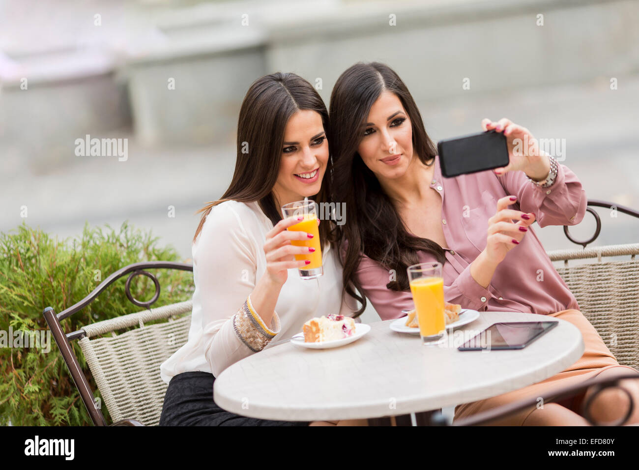 Junge Frauen, die Fotos mit dem Handy im café Stockfoto