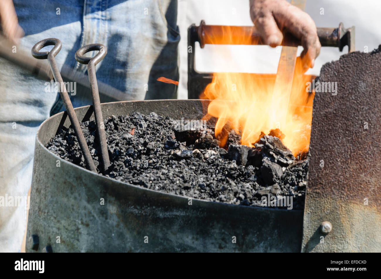 Ein Schmied erwärmt ein Stück Metall in einem Ofen Stockfoto