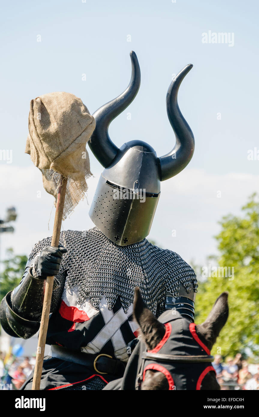 Ein Ritter Kettenhemd und ein gehörnter Helm tragen reitet vorbei auf dem Pferderücken Stockfoto