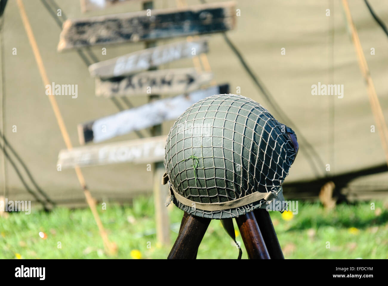 Helm ruht auf drei Waffen im 2. Weltkrieg Reenactment. Stockfoto