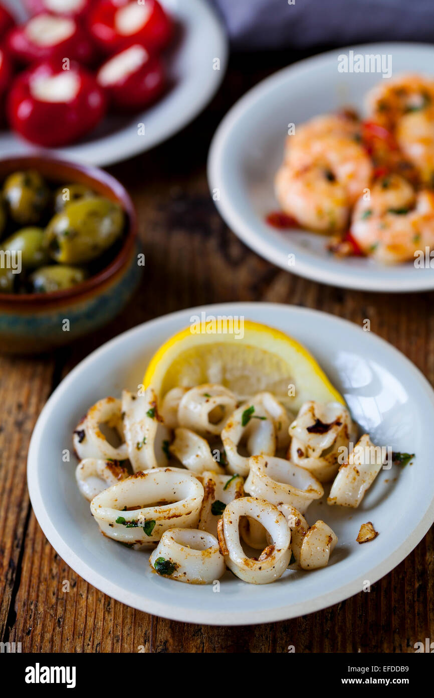 Tapas von Tintenfisch, gefüllte Paprika, Oliven und Garnelen Stockfoto
