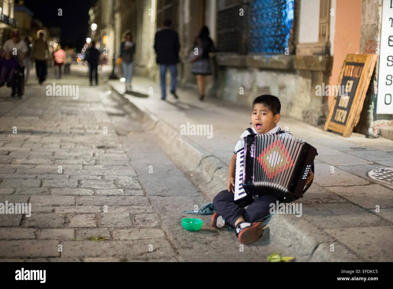 Oaxaca, Mexiko - ein sieben-Jahr-alter Junge spielt Akkordeon und singt für Tipps auf der Straße. Stockfoto