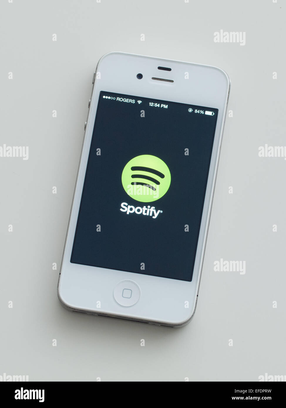 Ein Blick auf das Logo und die Homescreen der Spotify-app auf dem Apple iPhone 4. Stockfoto